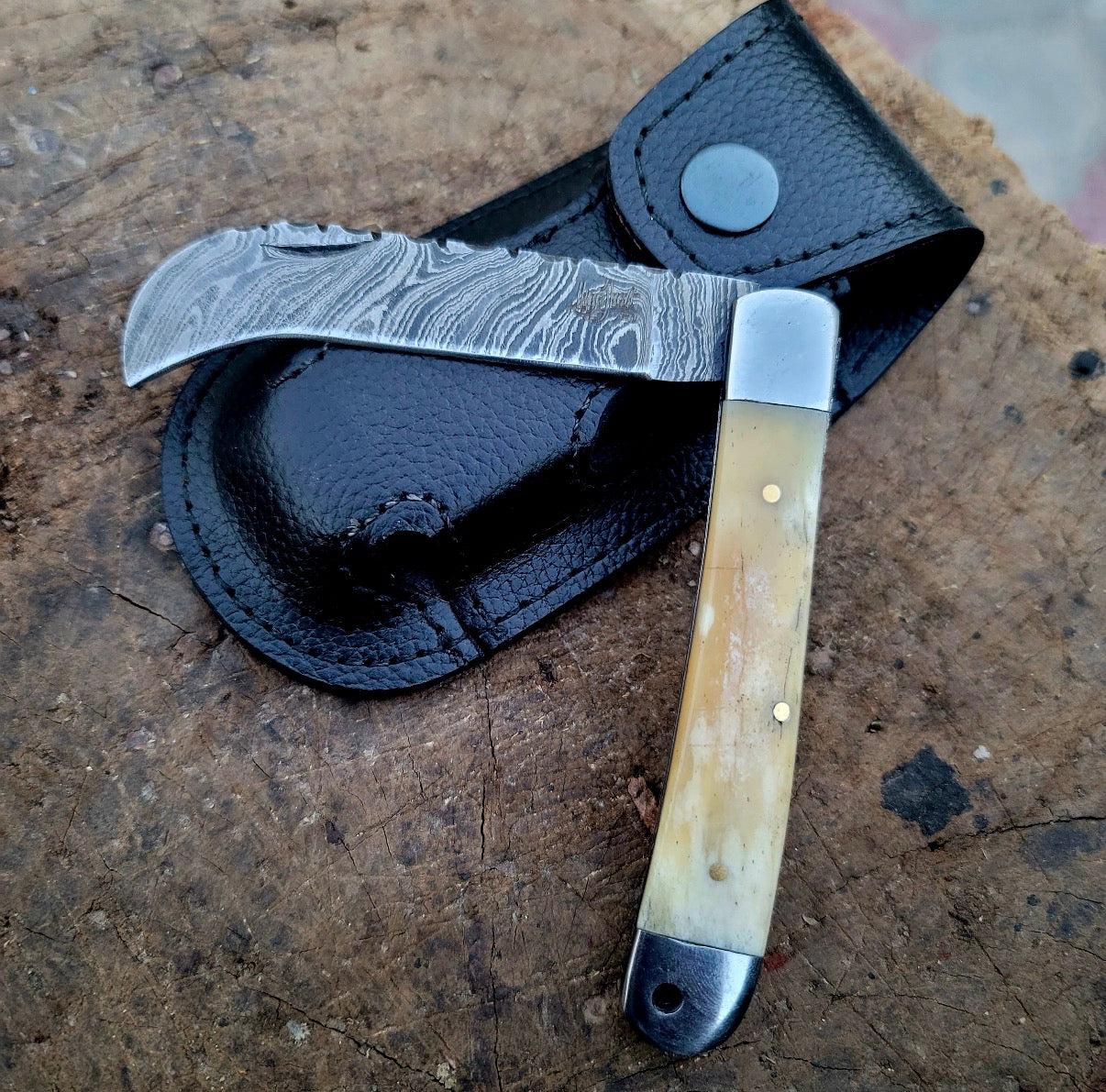 Hawkbill folding knife with leather sheath